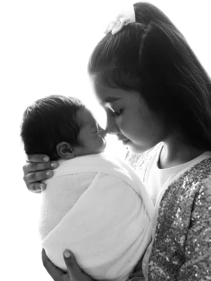 A protective embrace from a proud big sister. I work patiently to capture the natural love and curiosity that older siblings have for their new baby.
