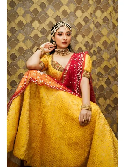 A full-length shot of the model in the yellow lehenga, showing a vibrant and festive look perfect for a mehendi or haldi ceremony.