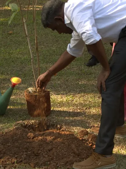 A staff member carefully prepares the soil for the new plant on Earth Day. Every herb planted is a step towards sustainable wellness and environmental harmony.