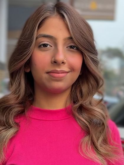 This front-facing view shows how the face-framing highlights and soft waves work together to create a stylish and flattering look. The color placement is key to this effect.