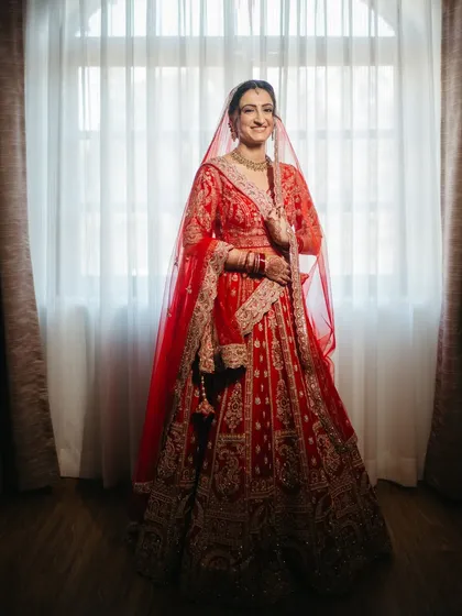 The classic red lehenga, the gentle smile, the quiet anticipation. I believe in capturing the timeless grace of a bride. This is more than a photo; it's an heirloom, a memory of the moment you stood on the threshold of forever.
