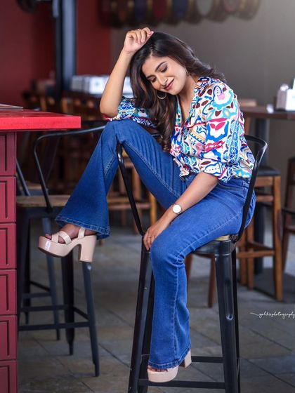 A lifestyle fashion shoot for an actress, featuring a colorful printed shirt and blue jeans. Shot in a modern cafe, these images have a bright, energetic, and youthful feel, perfect for a commercial or social media campaign.