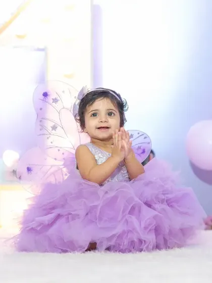 A round of applause for the birthday girl. This happy, clapping shot perfectly captures the joy and excitement of a first birthday celebration.