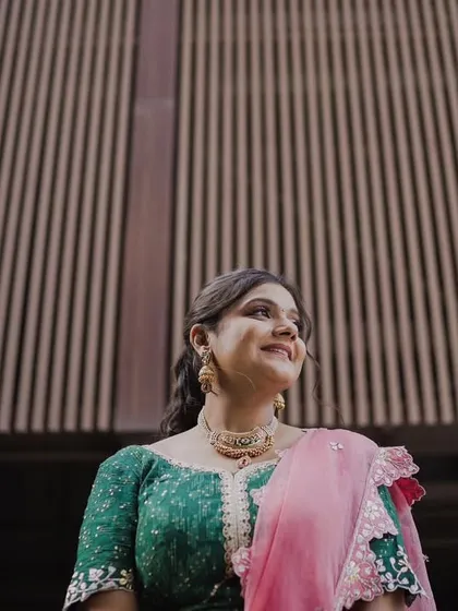 A minimal makeup look for a Mehendi bride. The focus is on clean skin and subtly defined eyes, allowing her natural beauty and the intricate henna to be the main attractions.