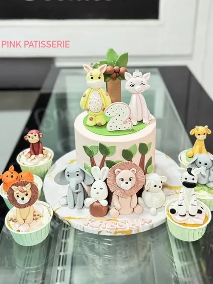 A full view of the jungle animal cake with its set of matching, individually decorated cupcakes.