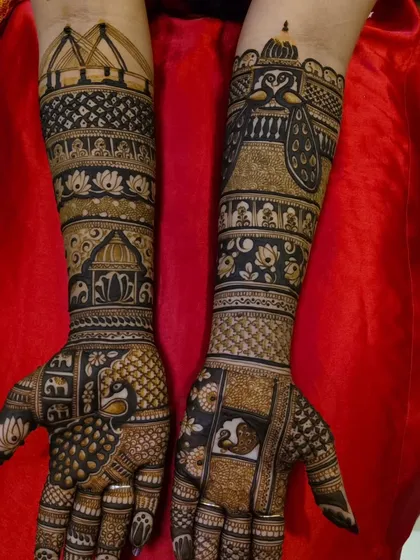This design showcases a mix of traditional patterns, including jaali (net), paisley, and a prominent peacock on the back of the hand.