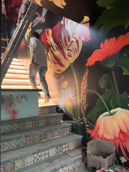 The staircase mural in progress, with the base colors blocked in and the intricate details beginning to take shape. This view shows how the artwork is integrated with the architecture from the very beginning.