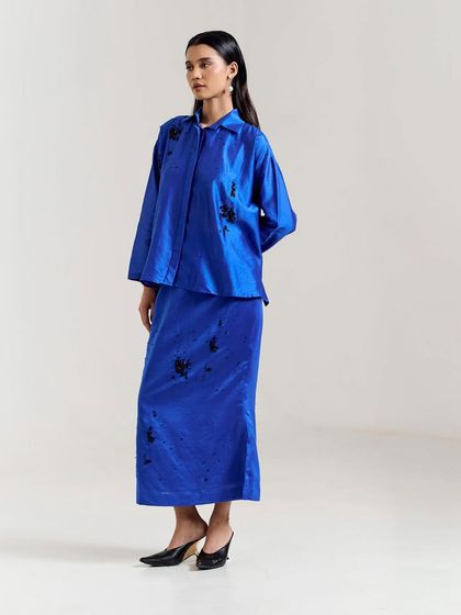 A striking royal blue co-ord set with a long skirt and matching top, featuring black floral embroidery for a touch of contrast and sophistication.
