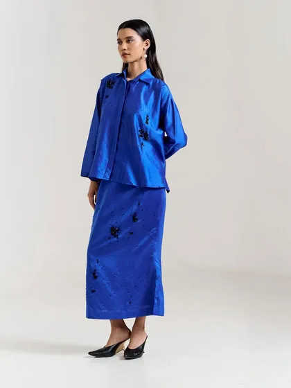 A striking royal blue co-ord set with a long skirt and matching top, featuring black floral embroidery for a touch of contrast and sophistication.