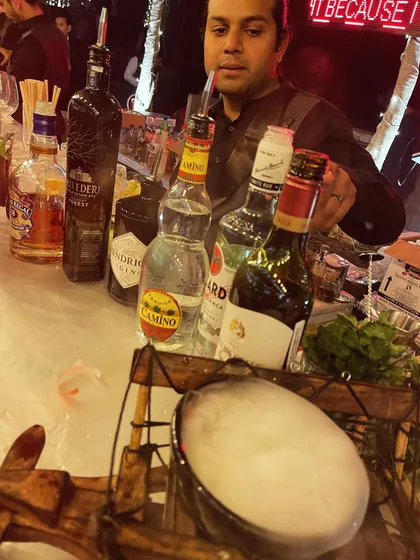 A bartender preparing a smoky cocktail at a birthday party. The entire bar, including the menu and special effects, was designed around the birthday person's preferences.