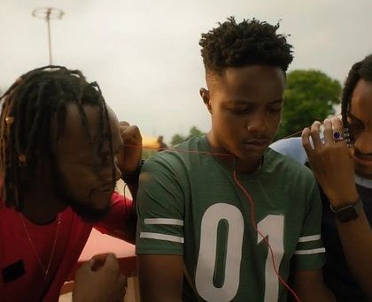 A quiet, shared moment between friends in the SanDisk commercial. The styling is casual and relaxed, using simple t-shirts and accessories to create relatable characters.