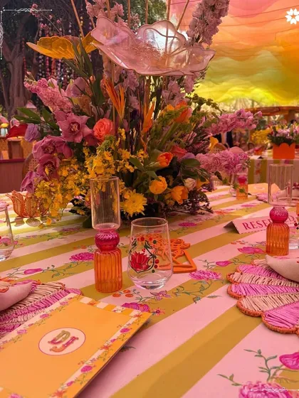A colourful and lively tablescape from a mehendi ceremony. The mix of patterns, florals, and colours creates a joyful atmosphere that perfectly complements a festive Indian celebration.
