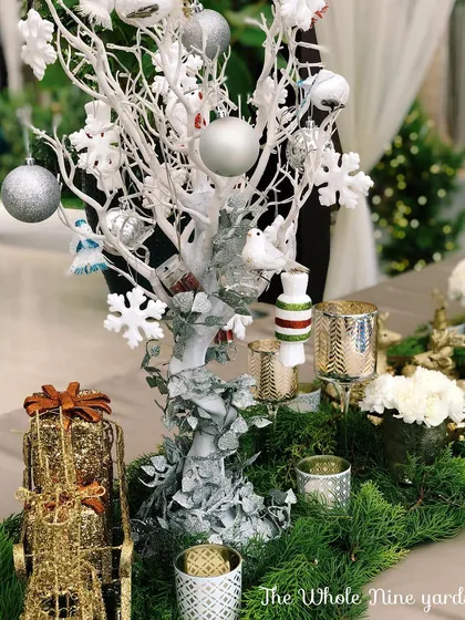 A white decorative tree centerpiece for the Christmas table, adorned with silver snowflakes and ornaments, adding to the magical winter wonderland theme.