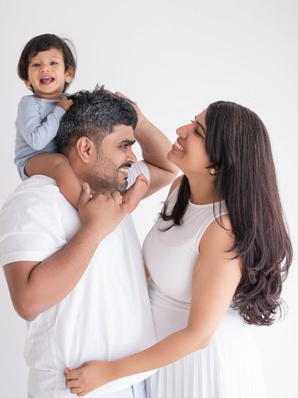A joyful family portrait with a toddler getting a shoulder ride from dad.