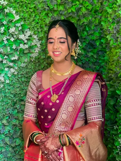 A candid moment capturing the soft, natural makeup and the intricate details of her traditional jewellery.
