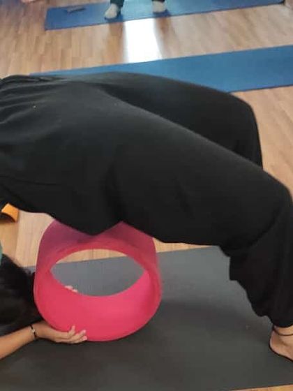 Here is another student working on her backbend with the yoga wheel. Notice how the prop helps maintain the curve of the spine, which is crucial for safe and effective practice.