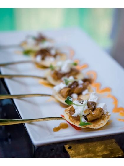 Miniature pancakes topped with savoury duck and a dollop of cream, served on elegant golden spoons. This presentation showcases our attention to detail and our ability to create luxurious, single bite appetizers.