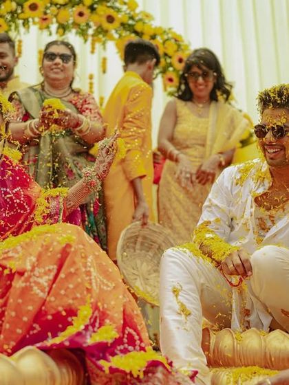 The couple gets showered with marigold petals during their Haldi, a classic and vibrant moment of celebration.