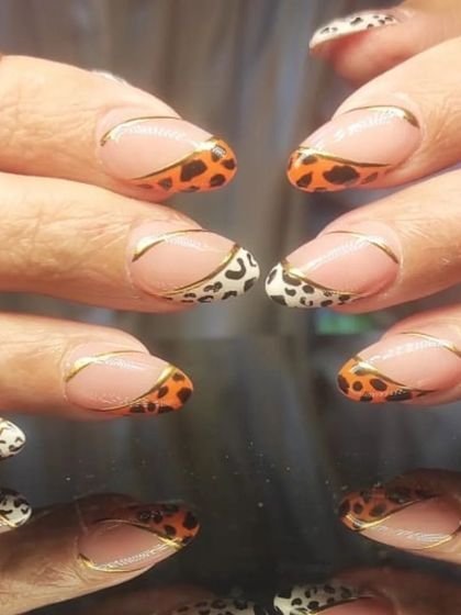 A wild and chic design featuring leopard print tips in two different colorways, outlined with a fine gold line.