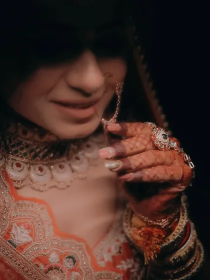 A close-up, artistic shot focusing on the bride's hand, her ring, and the intricate embroidery of her dress.