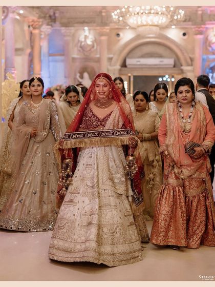 The bride's entrance during her Nikah ceremony, holding the decorative cloth as she walks towards the stage.