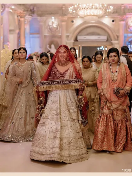 The bride's entrance during her Nikah ceremony, holding the decorative cloth as she walks towards the stage.