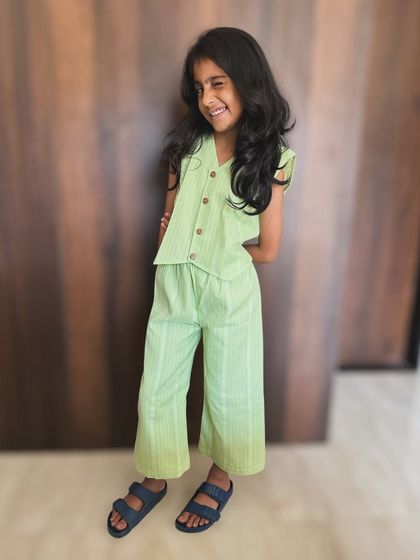 A cheeky wink and a comfy outfit, what more does a girl need? This green co-ord set with wooden button details is perfect for a day of play.
