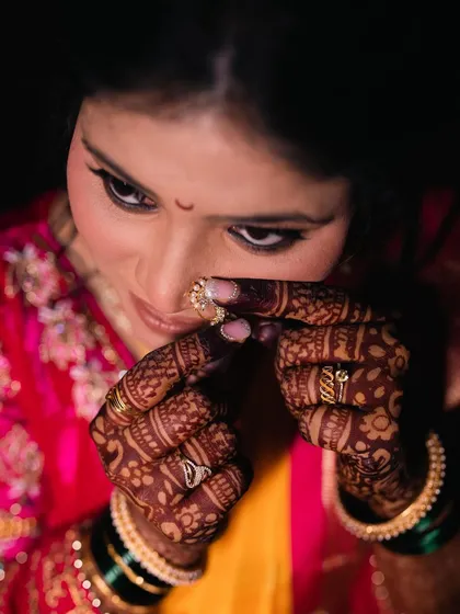 A close-up shot of the bride adjusting her nath, with perfectly blended brown smokey eyeshadow for her mangalashtak ceremony.