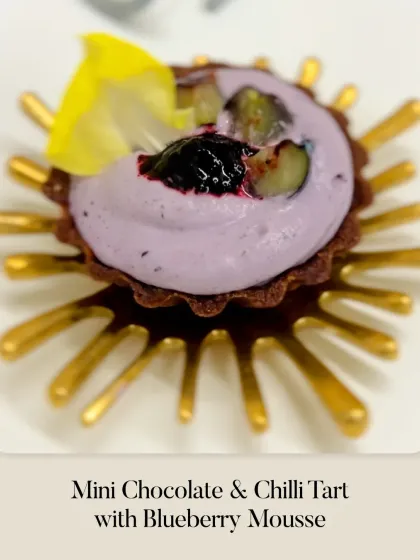 A Mini Chocolate & Chilli Tart with Blueberry Mousse. This dessert is a play on flavors, combining the richness of chocolate, a hint of chili, and the fruity lightness of blueberry mousse.
