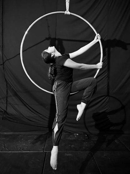 This artistic pose in black and white shows a student creating a beautiful shape within the hoop, pointing her toes to complete the elegant line.