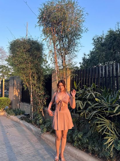 A happy, waving pose in the cute pink dress.