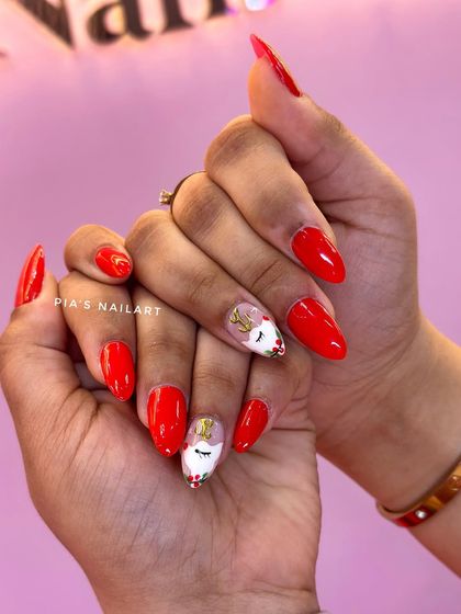 A minimal but festive Christmas look. A bright, classic red with a cute unicorn reindeer accent nail.