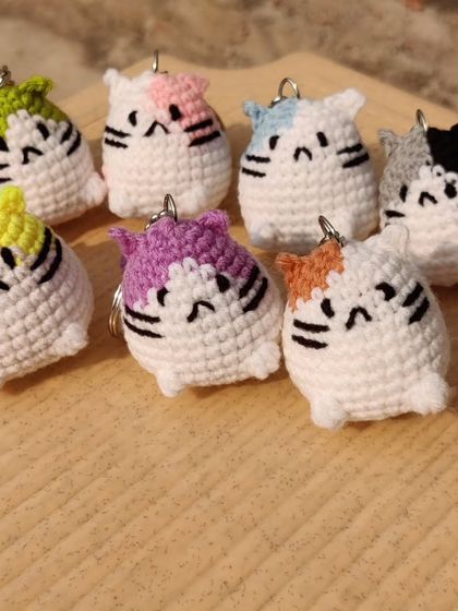 My collection of chubby cat keychains. These little guys come with different colored patches on their heads, including yellow, green, pink, blue, and grey.