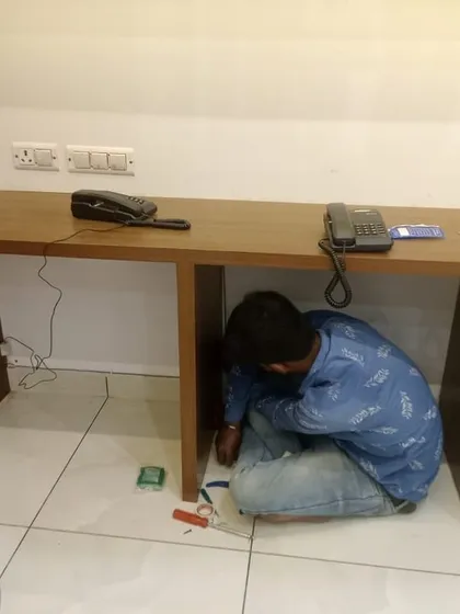 One of my technicians working on the wiring for the EPABX system under a desk. We take care of the entire installation process from start to finish.