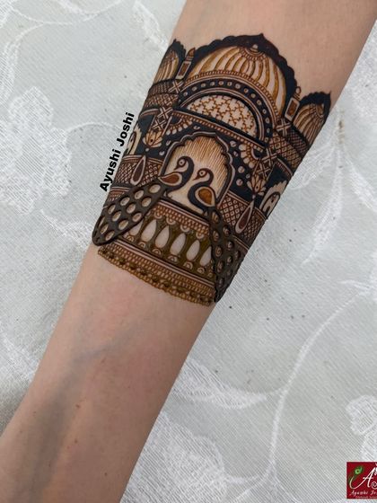 A close-up of a peacock and palace design, showcasing the use of negative space and bold filling to make the motifs pop.