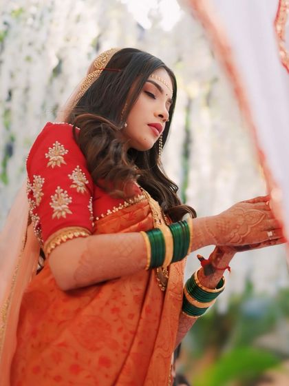 A serene shot of the bride during the wedding rituals. Her side profile highlights the soft waves in her hair and her delicate makeup.