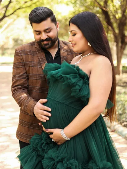 A loving close-up of the couple. The dad-to-be gently holds the bump, both of them looking down with sweet anticipation.
