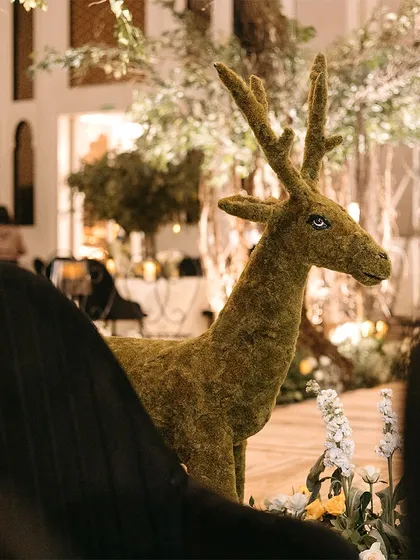 A life-sized deer statue covered in green moss, part of an enchanted forest theme. These unique props help to build a truly immersive and fairytale-like world.
