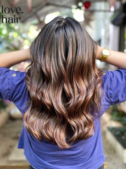 The same balayage in a different light. This shot, taken outdoors, shows how the caramel tones become even warmer and more vibrant in natural sunlight.