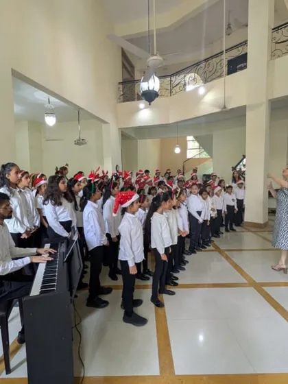 A large ensemble of our younger choir students, led by their conductor and a student accompanist, fills the hall with the sound of Christmas music.