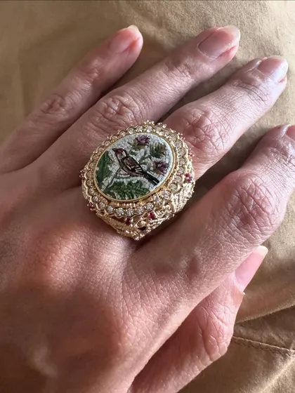 This micromosaic ring captures a small bird perched on a branch. It is set in an ornate 18k gold band with rubies and diamonds.