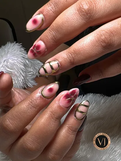 An elegant mix of deep wine florals and edgy gold geometric lines. This design showcases how to balance different artistic styles on one set of nails.