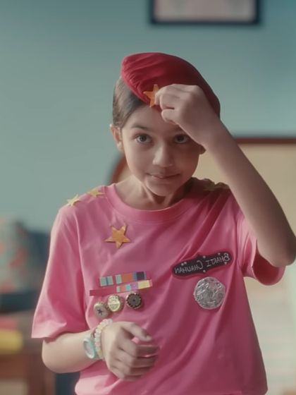 The story began here, with the character as a child dreaming of the future. I created this playful, DIY army uniform with a pink t-shirt and handmade medals to capture the innocence and ambition of her childhood aspirations.