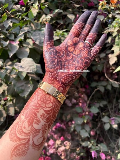 A single-arm view of a mature henna stain, showcasing the deep red and brown tones of the floral design.