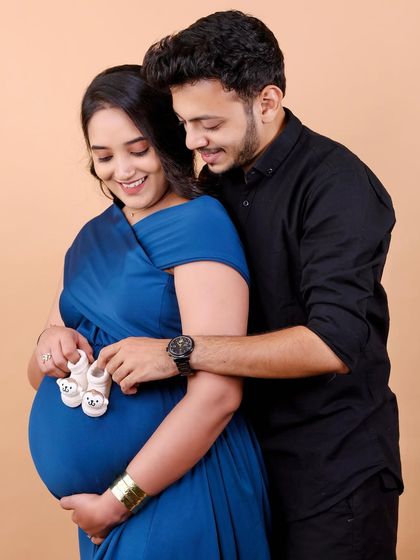 The tiniest shoes for the tiniest feet. This close-up shot of the couple holding baby shoes against the bump is a sweet and classic way to symbolize the new life you're waiting for.