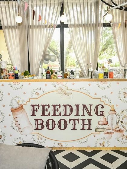 A custom-designed 'Feeding Booth' for the bar area, tying into the rustic teddy bear theme with its charming illustrations and font.