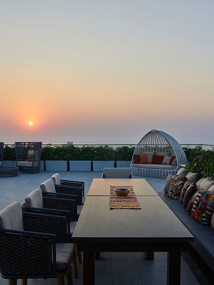 The sea-facing portion of the terrace at sunset, designed as a space for repose with comfortable lounge furniture and unobstructed views.