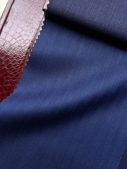 A swatch of royal blue wool next to a textured leather sample, showing how we help clients consider different textures and materials.