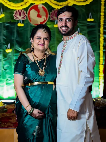 A smiling couple stands together at their baby shower event. I aim to capture both individual portraits and photos that show the couple's partnership.