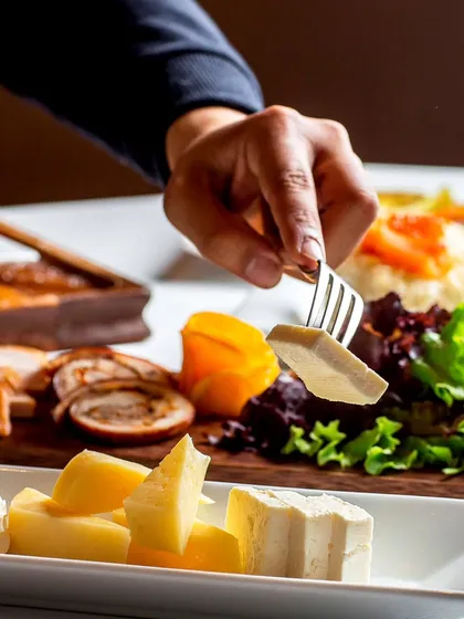 A gourmet cheese and charcuterie platter being served. This demonstrates our expertise in creating sophisticated offerings for upscale events and cocktail parties.